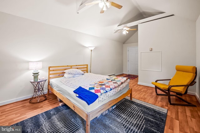 bedroom featuring vaulted ceiling, wood finished floors, and baseboards