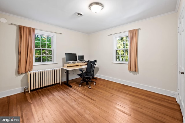 home office featuring visible vents, ornamental molding, radiator heating unit, and hardwood / wood-style floors