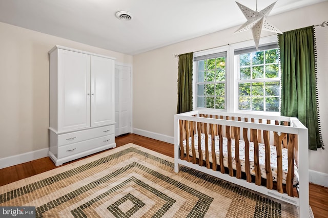 bedroom featuring visible vents, baseboards, and wood finished floors