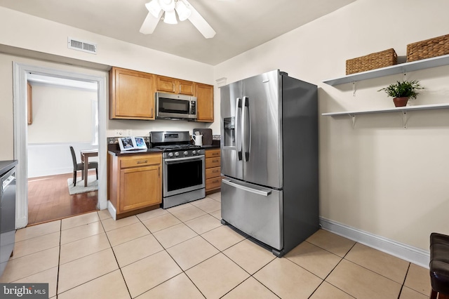 kitchen featuring stainless steel appliances, visible vents, light tile patterned flooring, and brown cabinetry