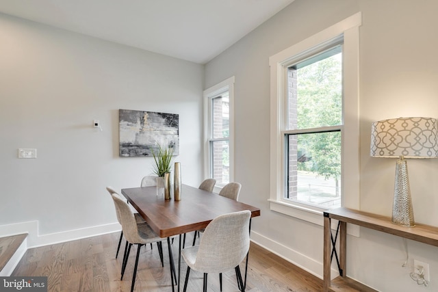 dining space with baseboards and wood finished floors