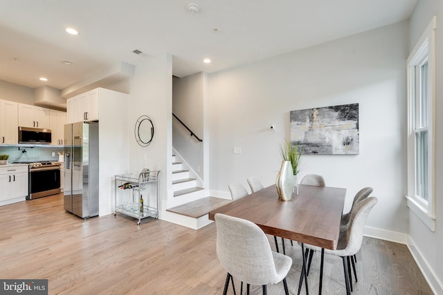 dining area with recessed lighting, baseboards, stairs, and light wood finished floors