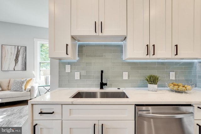 kitchen with a sink, white cabinetry, and stainless steel dishwasher