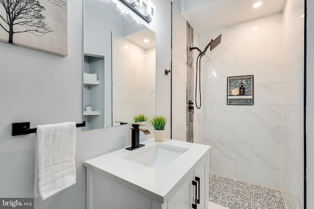 bathroom featuring recessed lighting, tiled shower, and vanity