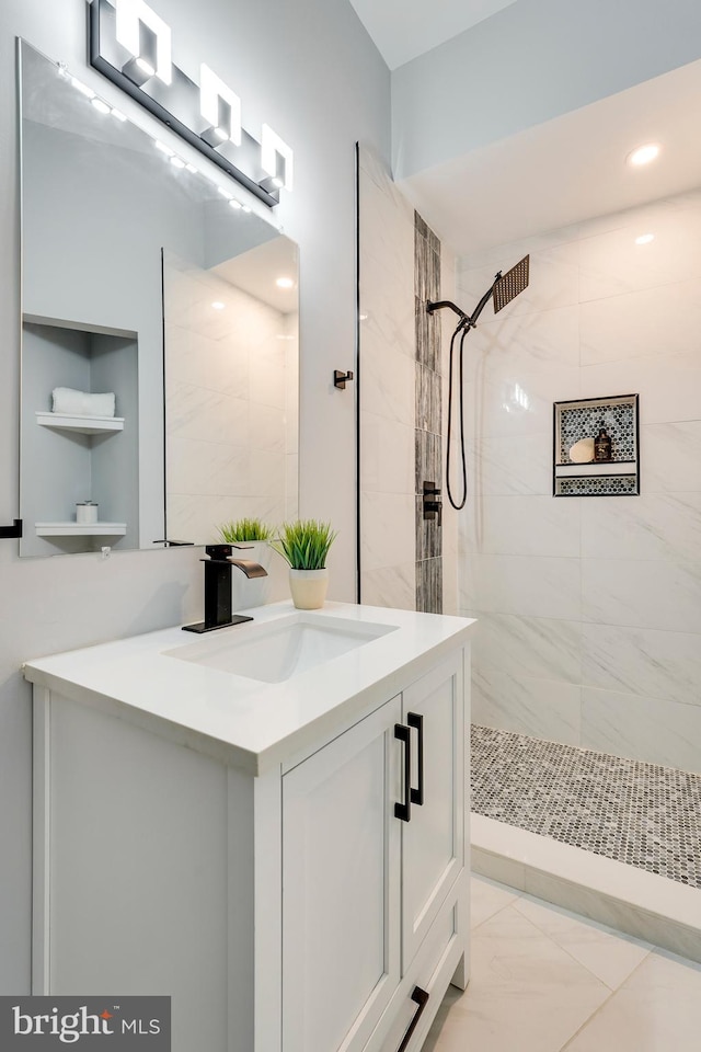 full bathroom featuring a tile shower, recessed lighting, marble finish floor, and vanity