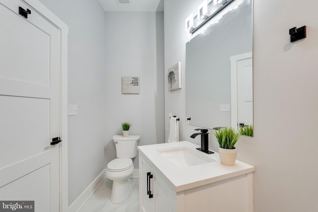 half bath with visible vents, toilet, marble finish floor, baseboards, and vanity