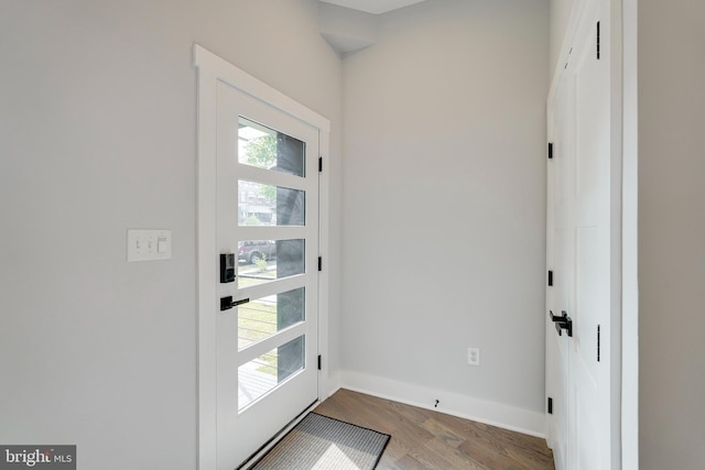 doorway featuring wood finished floors and baseboards