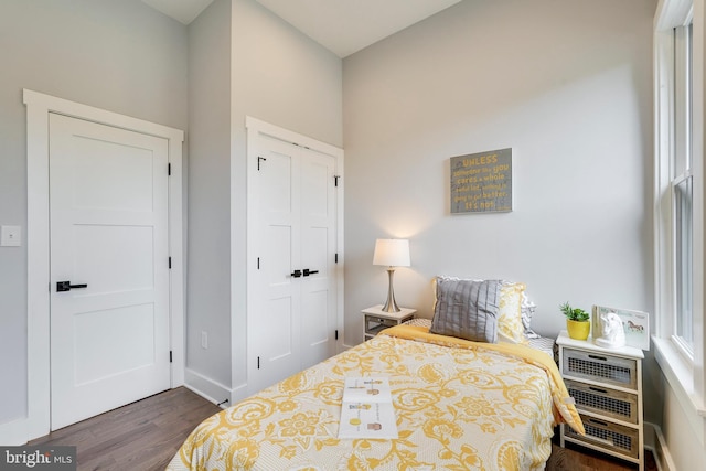 bedroom featuring wood finished floors, a closet, and baseboards