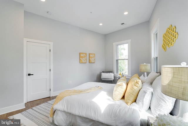 bedroom featuring recessed lighting, visible vents, baseboards, and wood finished floors