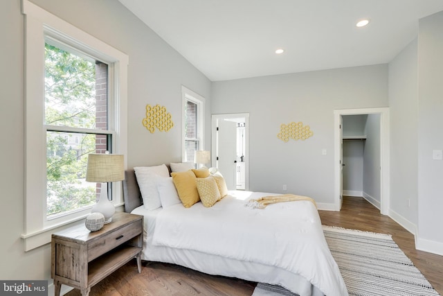 bedroom featuring recessed lighting, multiple windows, baseboards, and wood finished floors