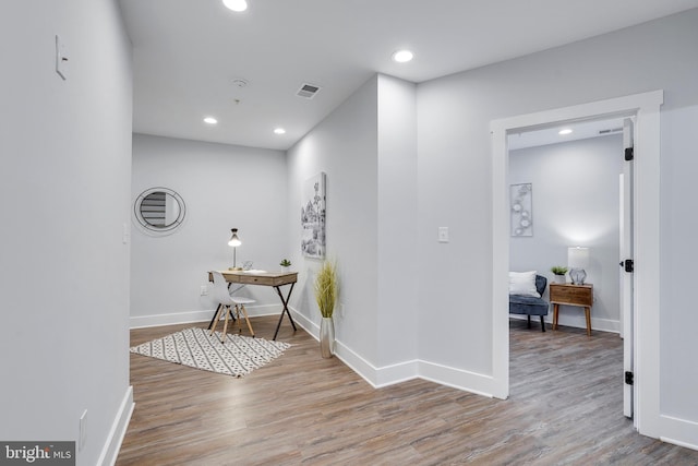 hall featuring visible vents, recessed lighting, baseboards, and wood finished floors