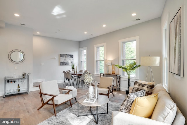 living area featuring recessed lighting, visible vents, baseboards, and light wood finished floors