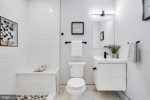 bathroom featuring tiled shower, marble finish floor, toilet, and vanity