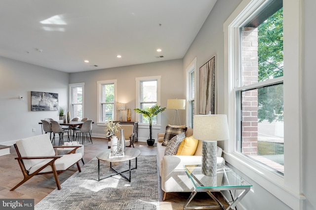 living area featuring recessed lighting, wood finished floors, visible vents, and baseboards