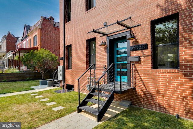 property entrance with a yard and brick siding