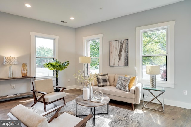 living area with plenty of natural light, wood finished floors, and visible vents