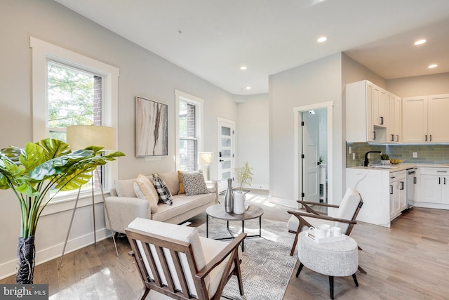 living room with recessed lighting, light wood-style flooring, and baseboards