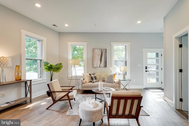 living room with recessed lighting, visible vents, baseboards, and light wood-style floors