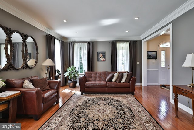 living room with light wood finished floors, recessed lighting, crown molding, and baseboards