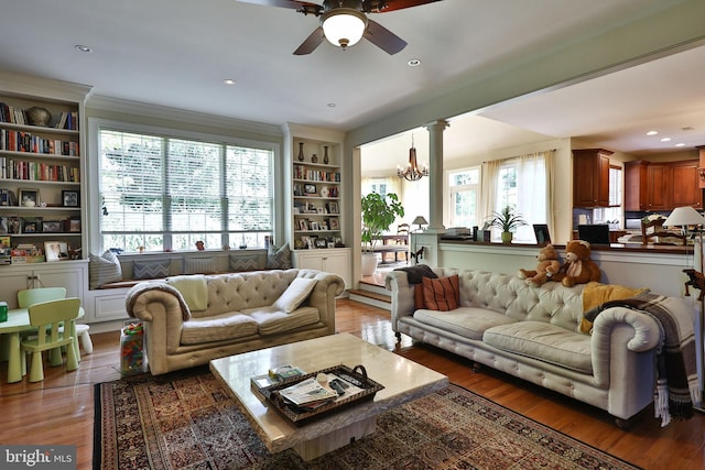 living room featuring recessed lighting, wood finished floors, crown molding, and ceiling fan with notable chandelier