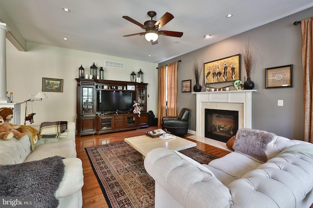 living room featuring visible vents, recessed lighting, wood finished floors, and a glass covered fireplace