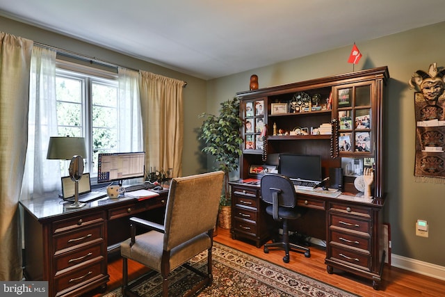 office area with dark wood-type flooring and baseboards