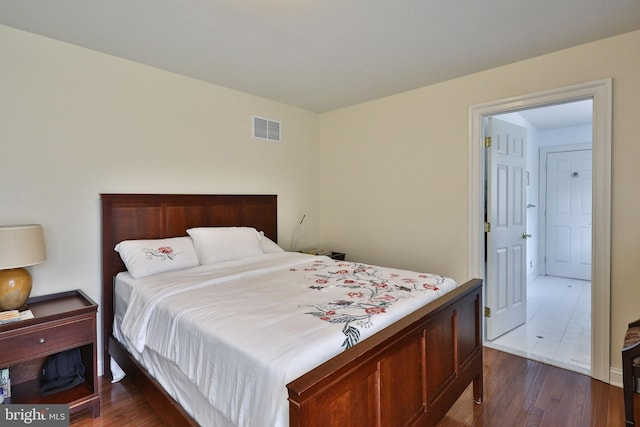 bedroom with visible vents and dark wood finished floors