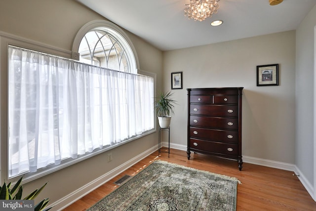 sitting room featuring visible vents, baseboards, and wood finished floors