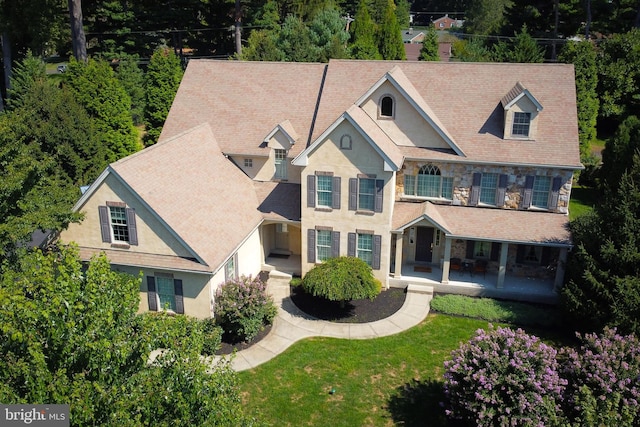 view of front of home featuring stone siding, stucco siding, and a front yard