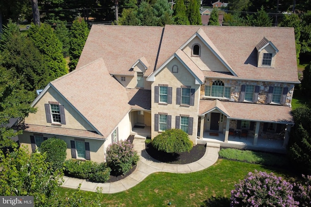 view of front of home with stone siding, stucco siding, and a front lawn