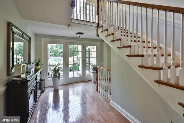 foyer entrance featuring hardwood / wood-style flooring, a high ceiling, and stairway