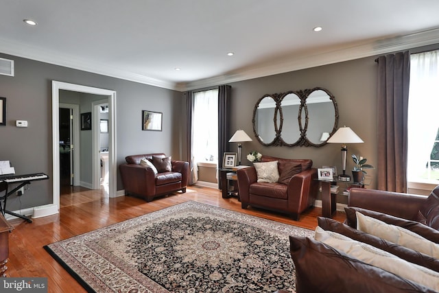 living room featuring visible vents, crown molding, baseboards, recessed lighting, and wood-type flooring