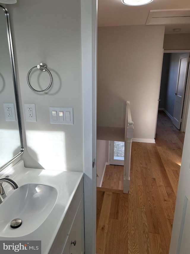 bathroom featuring vanity, baseboards, and wood finished floors