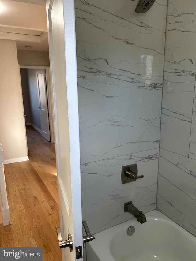 bathroom featuring shower / bathing tub combination, wood finished floors, and baseboards