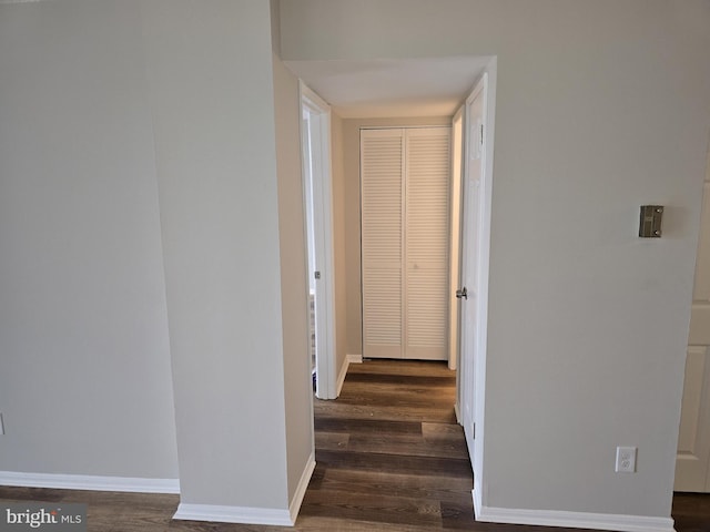 hallway featuring baseboards and wood finished floors