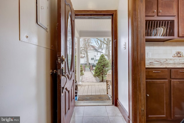 doorway to outside with light tile patterned flooring