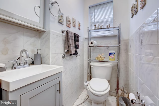 bathroom with tile walls, toilet, and vanity