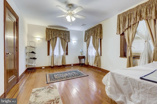 bedroom with visible vents, wood finished floors, and baseboards