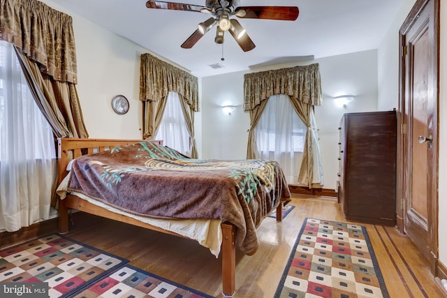 bedroom featuring ceiling fan, visible vents, and light wood-style flooring