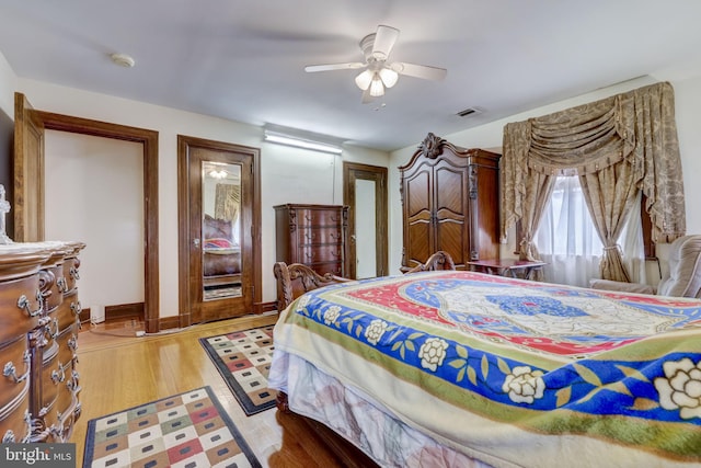 bedroom with visible vents, a ceiling fan, light wood-type flooring, and baseboards