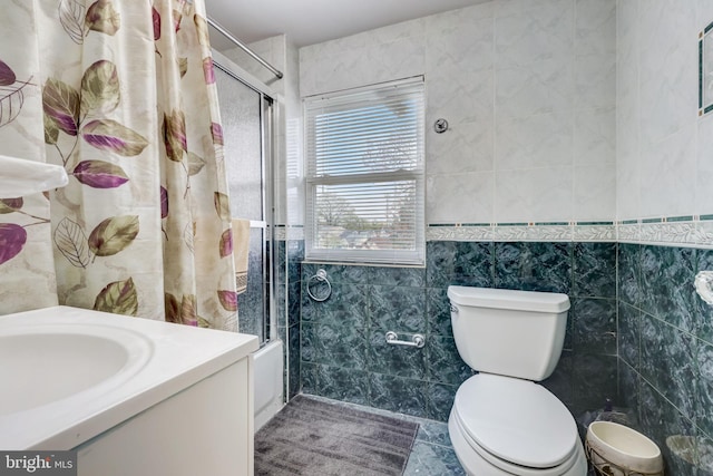 bathroom with vanity, tile walls, and toilet