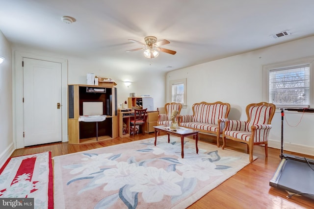 sitting room featuring baseboards, wood finished floors, visible vents, and ceiling fan