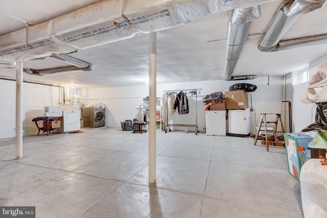 below grade area featuring brick wall and separate washer and dryer