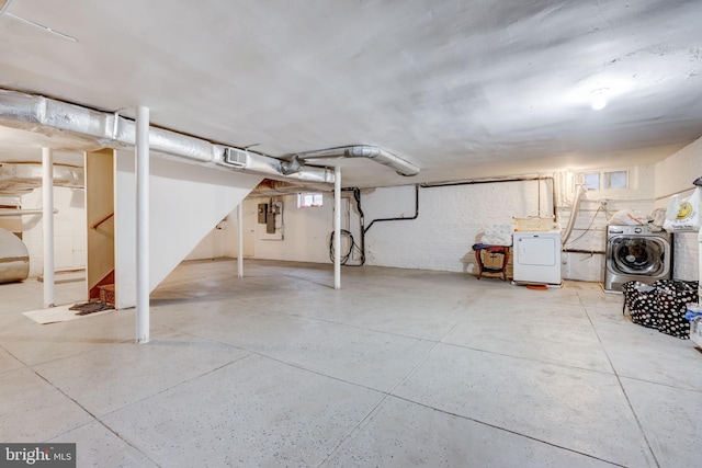 unfinished basement with stairs, electric panel, and washing machine and clothes dryer