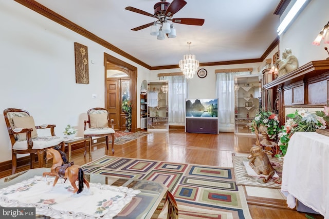 sitting room with baseboards, ceiling fan with notable chandelier, wood finished floors, and ornamental molding