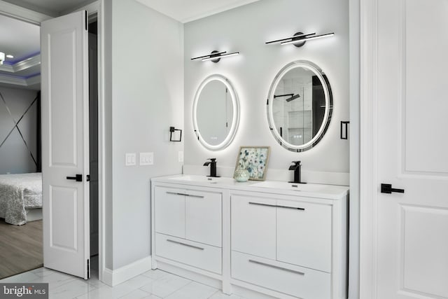 bathroom featuring a sink, baseboards, marble finish floor, and double vanity