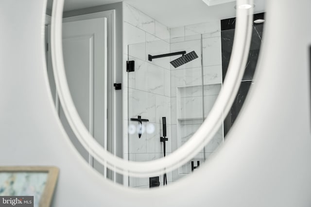 interior details featuring a marble finish shower