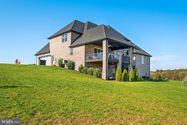 view of property exterior with brick siding, ceiling fan, a yard, a garage, and a balcony