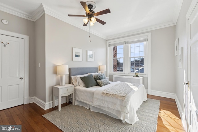 bedroom with baseboards, wood-type flooring, ornamental molding, and radiator heating unit