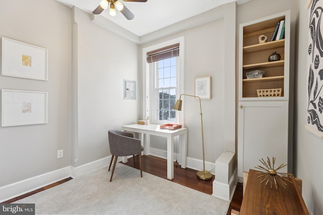 office area with electric panel, ceiling fan, and baseboards